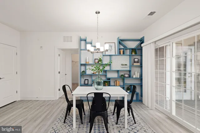 a dining room with furniture a chandelier and wooden floor