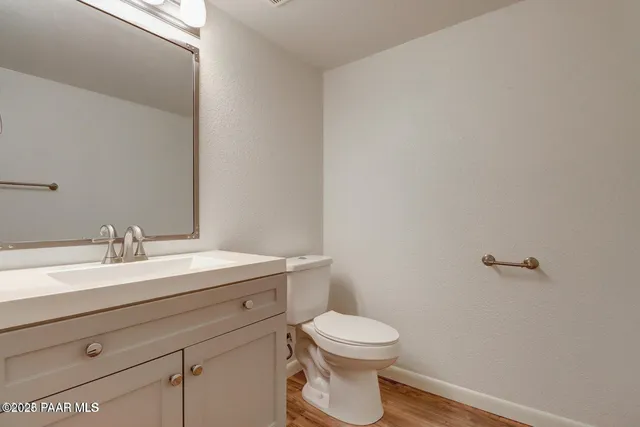 a bathroom with a granite countertop toilet a sink and mirror