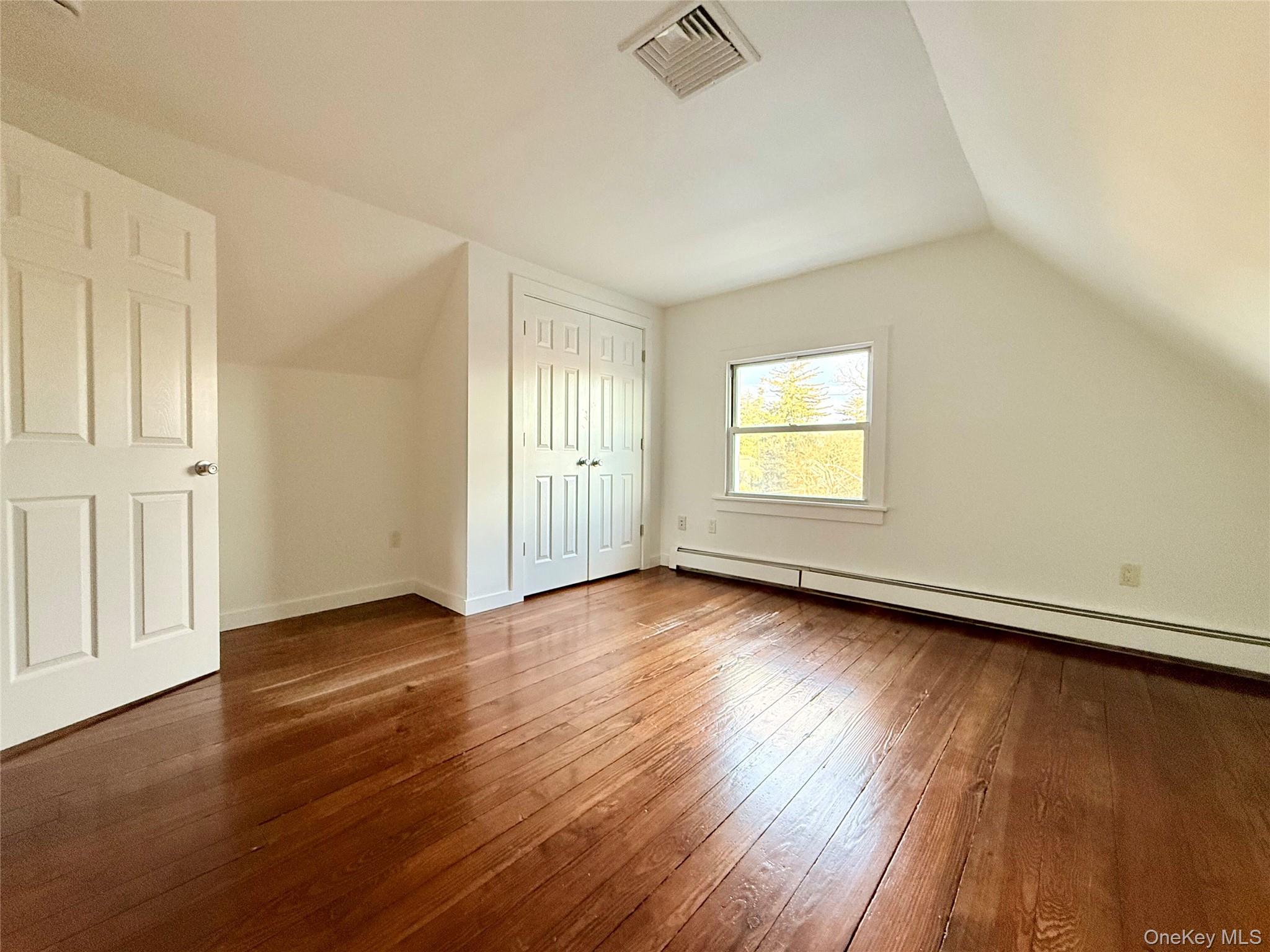 102 North Midland Avenue, Unit 2 Nyack, NY 10960 - Photo 14 of 19 an empty room with wooden floor and windows