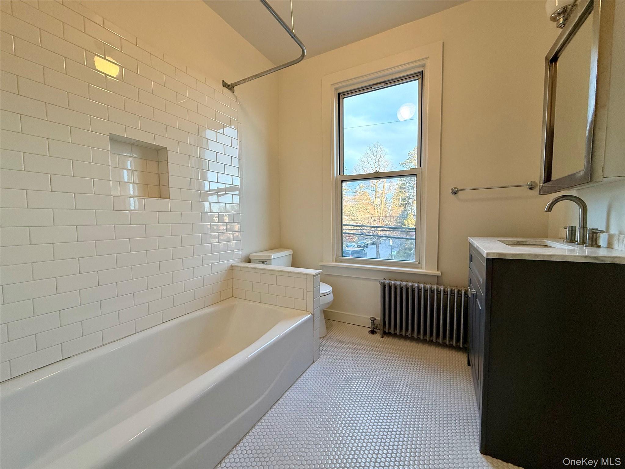 102 North Midland Avenue, Unit 2 Nyack, NY 10960 - Photo 9 of 19 a bathroom with a bathtub a sink and a window