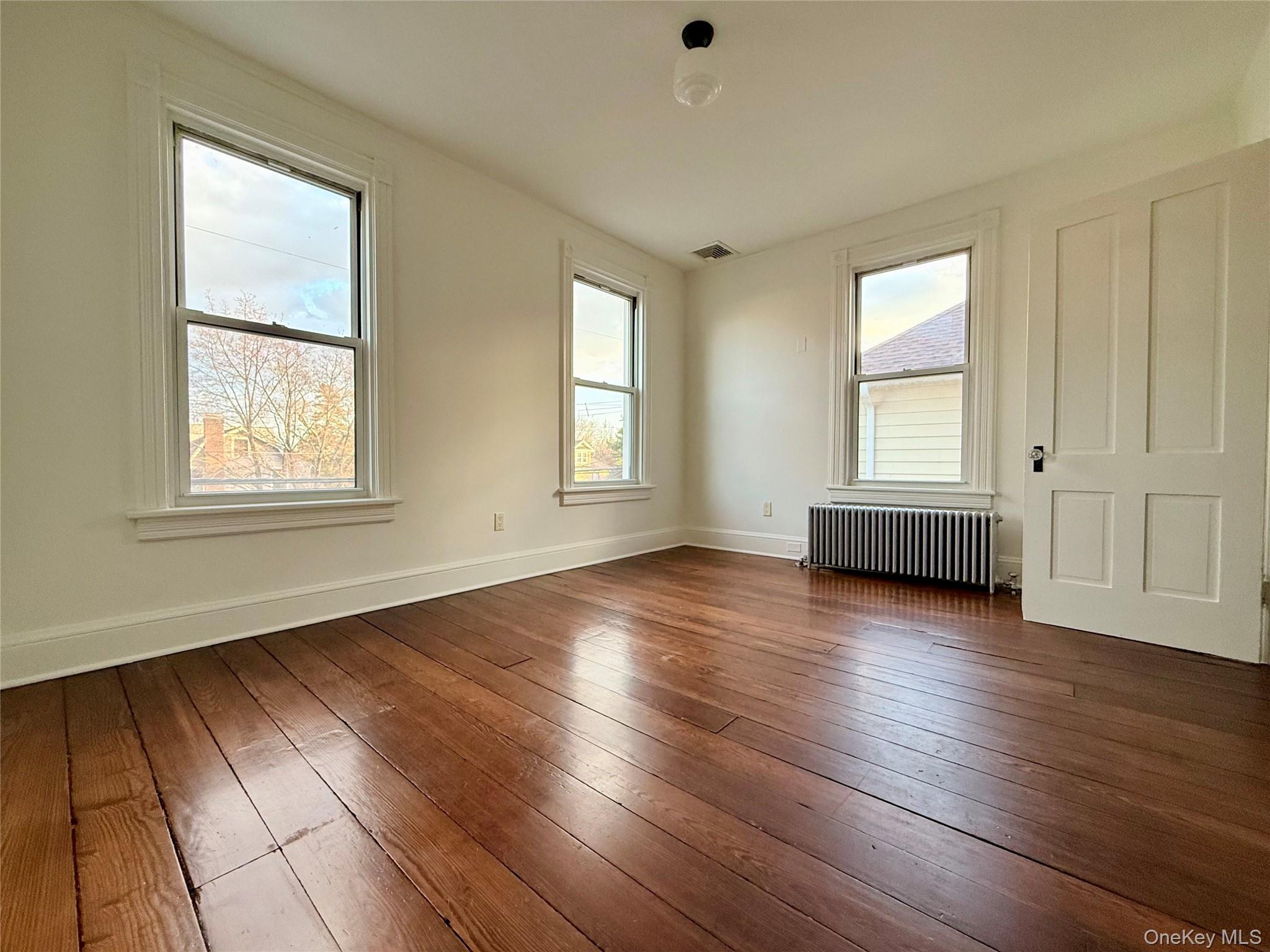 102 North Midland Avenue, Unit 2 Nyack, NY 10960 - Photo 10 of 19 an empty room with wooden floor and windows