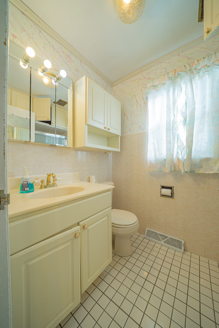 3437 Scott Street Franklin Park, IL 60131 - Photo 17 of 44 a bathroom with a sink a toilet and a mirror