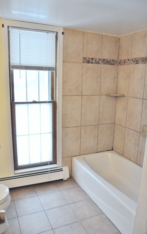 8-10 Bennington Street Newton, MA 02458 - Photo 20 of 22 a bathroom with a bathtub and next to a window