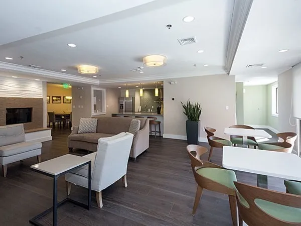 a living room with furniture kitchen view and a wooden floor