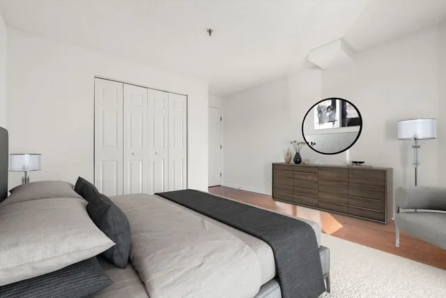 a bedroom with a bed a mirror and wall clock