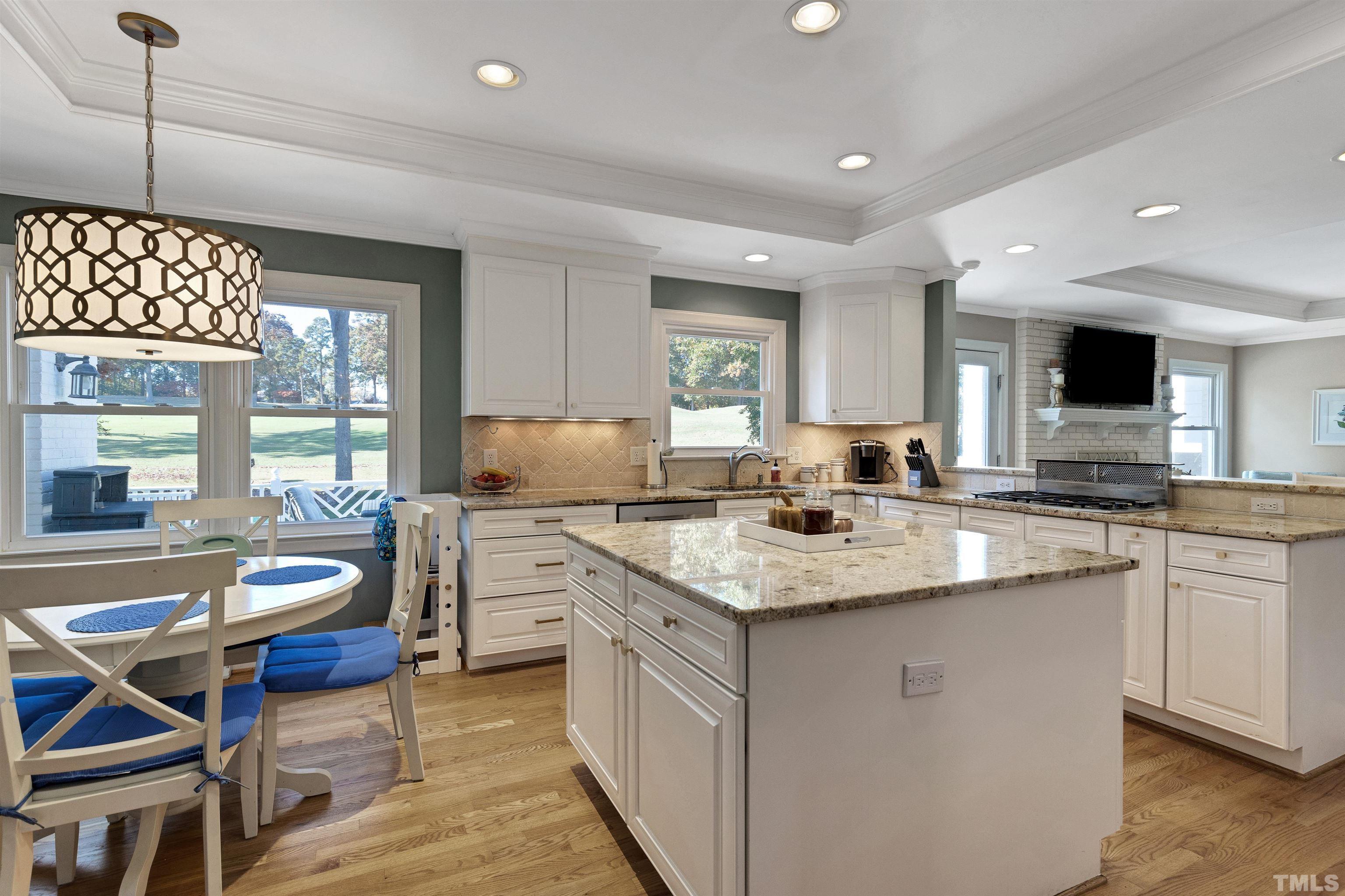 6813 Foxfire Place Raleigh, NC 27615 - Photo 13 of 38 a kitchen with a stove a sink a dining table and chairs
