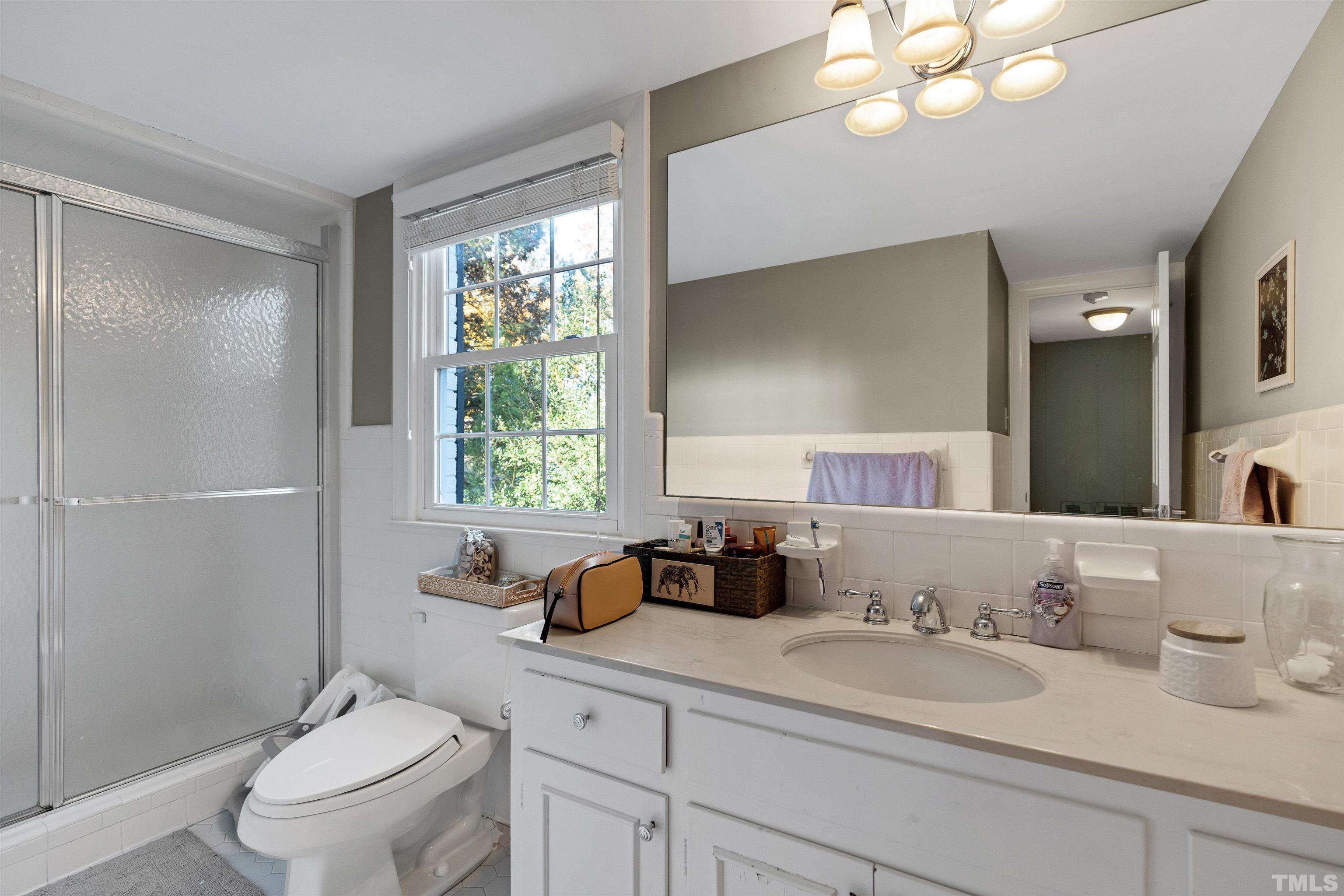 6813 Foxfire Place Raleigh, NC 27615 - Photo 17 of 38 a bathroom with a double vanity sink toilet and a mirror