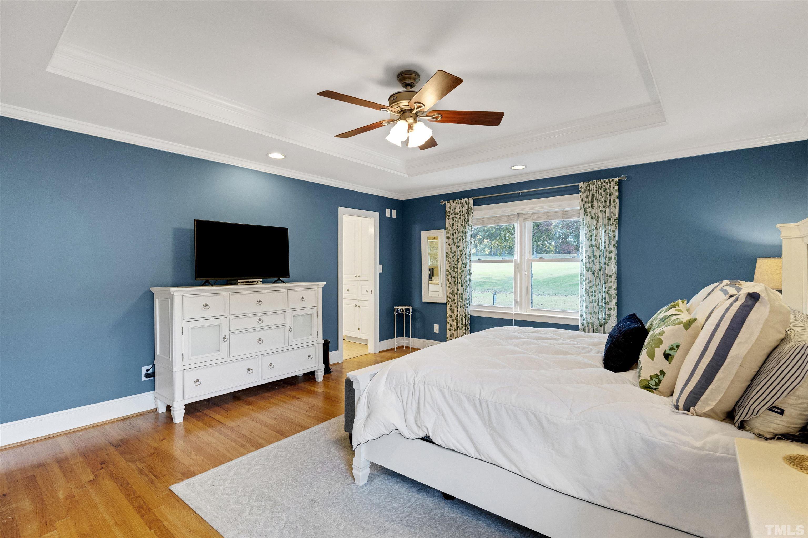 6813 Foxfire Place Raleigh, NC 27615 - Photo 24 of 38 a bedroom with a bed and flat tv screen on the dresser