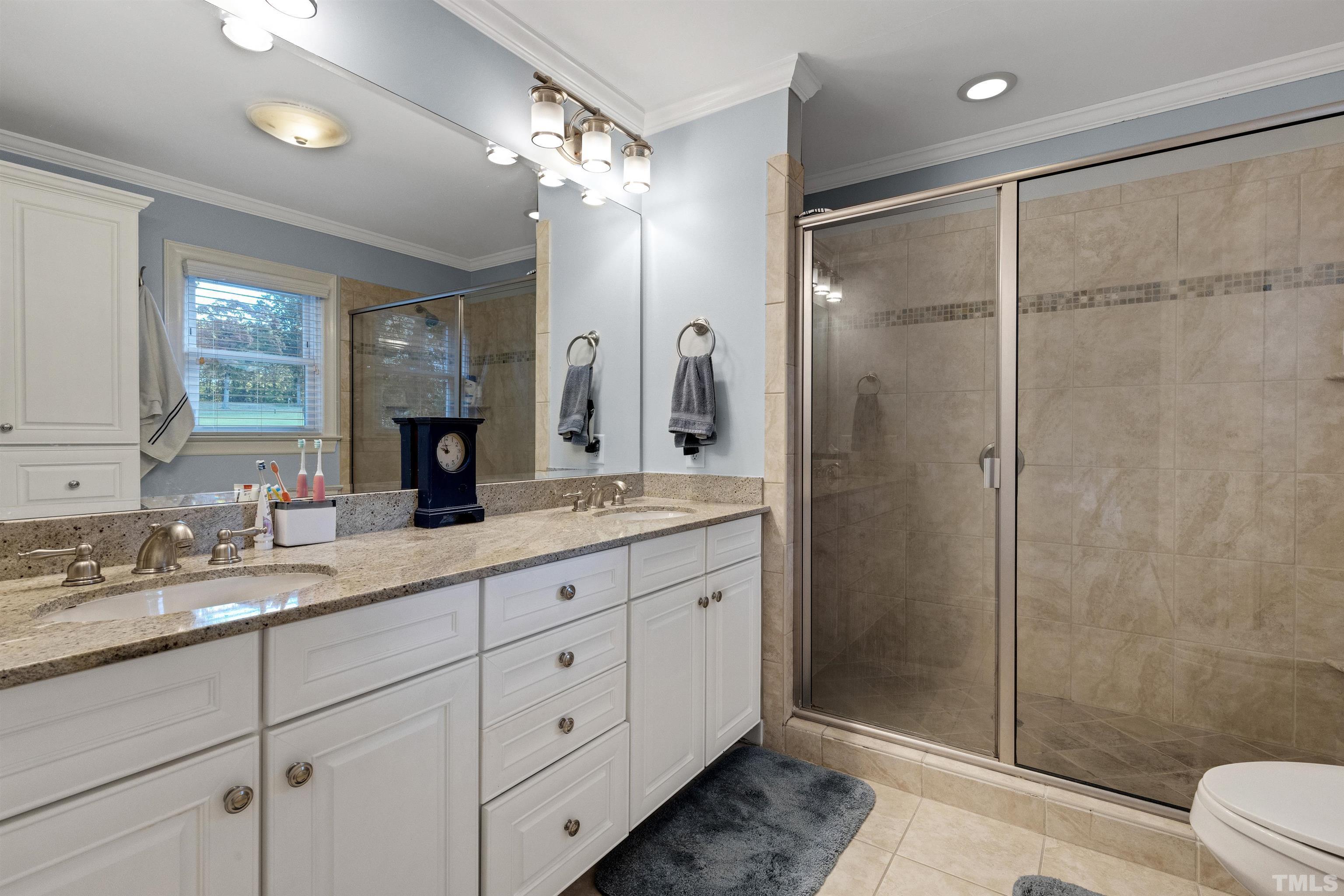 6813 Foxfire Place Raleigh, NC 27615 - Photo 25 of 38 a bathroom with a double vanity sink toilet and shower