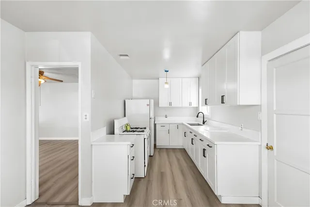 a kitchen with white cabinets sink and stainless steel appliances