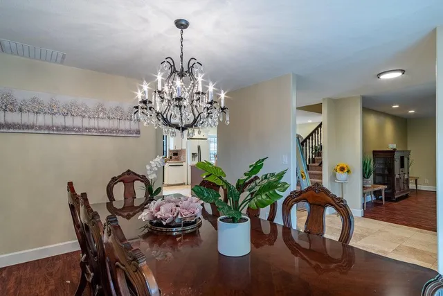 a kitchen with kitchen island granite countertop lots of wooden cabinets a dining table and chairs