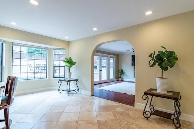 a kitchen with stainless steel appliances granite countertop a table chairs and a refrigerator