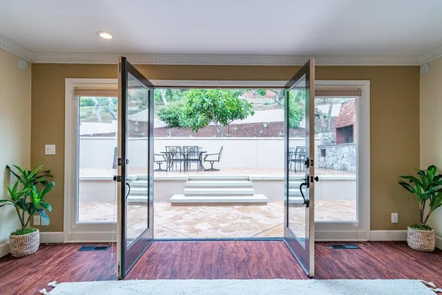 a view of a livingroom with a flat screen tv wooden floor and a ceiling fan
