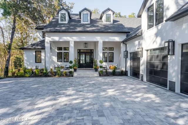 a view of a house with a big yard and large trees