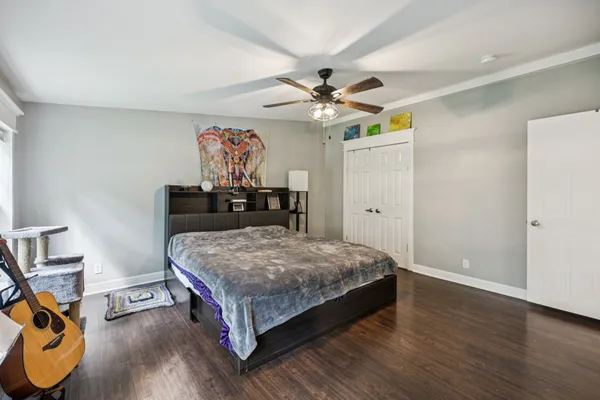 a bedroom with a bed and wooden floor