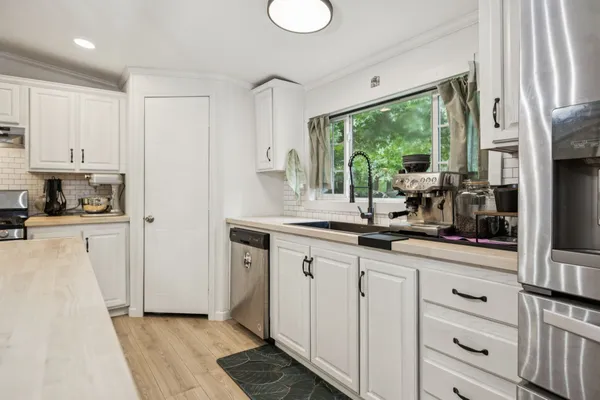a kitchen with granite countertop white cabinets and white appliances