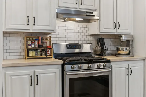 a stove top oven sitting inside of a kitchen