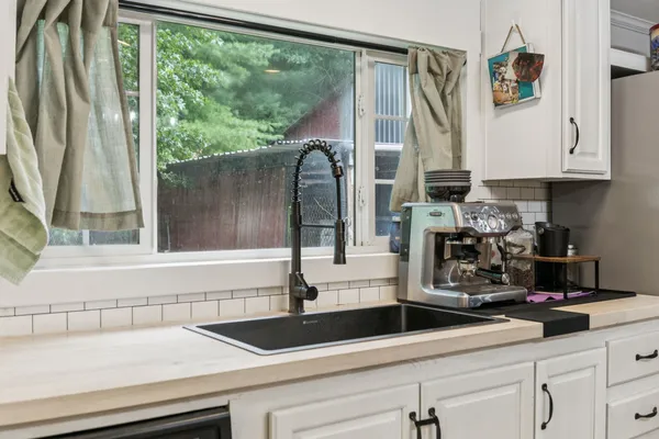 a kitchen with stainless steel appliances granite countertop a sink a refrigerator and a counter space