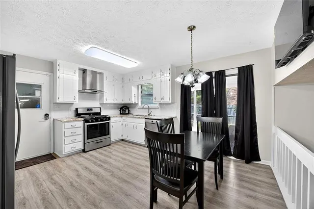 a kitchen with granite countertop stainless steel appliances a dining table chairs and granite counter tops