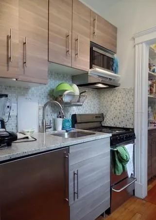 a kitchen with stainless steel appliances granite countertop a sink a stove and microwave