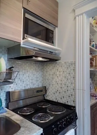 a stove top oven sitting inside of a kitchen