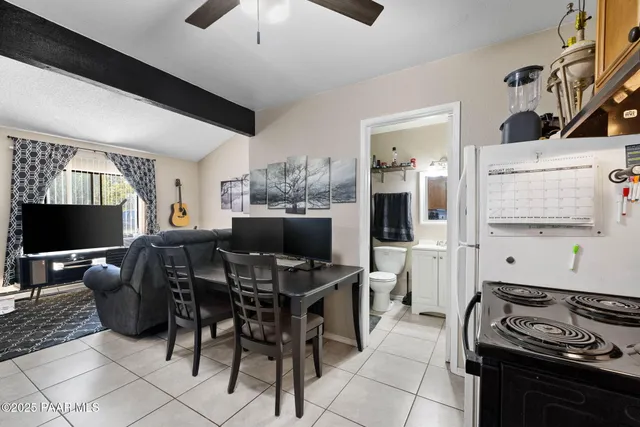 a kitchen with stainless steel appliances kitchen island granite countertop a stove top oven a sink a dining table and chairs with wooden floor