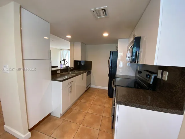 a kitchen with a sink stainless steel appliances and cabinets