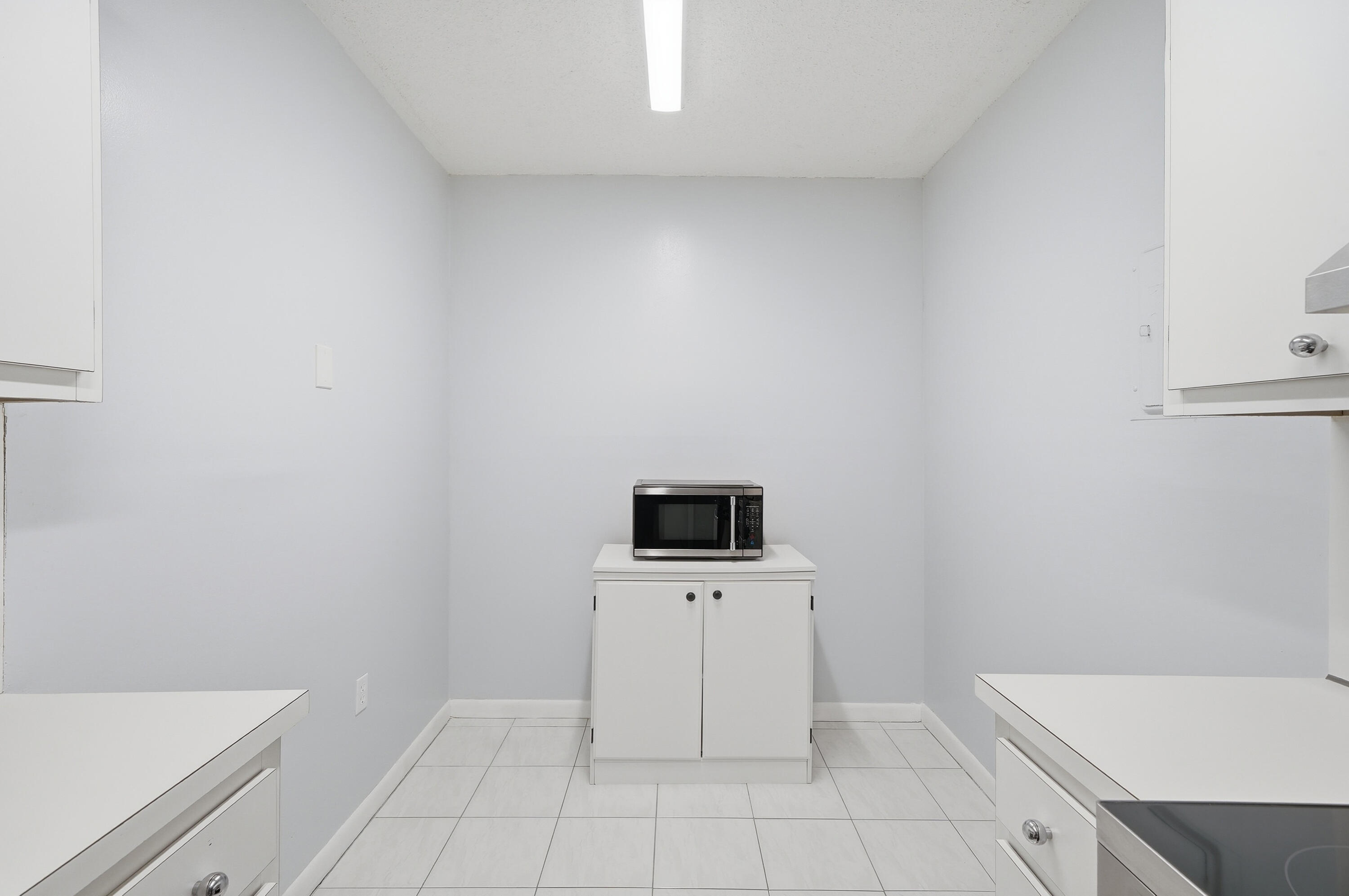 3850 Washington Street, Unit 1003 Hollywood, FL 33021 - Photo 13 of 30 a view of a kitchen with white cabinets