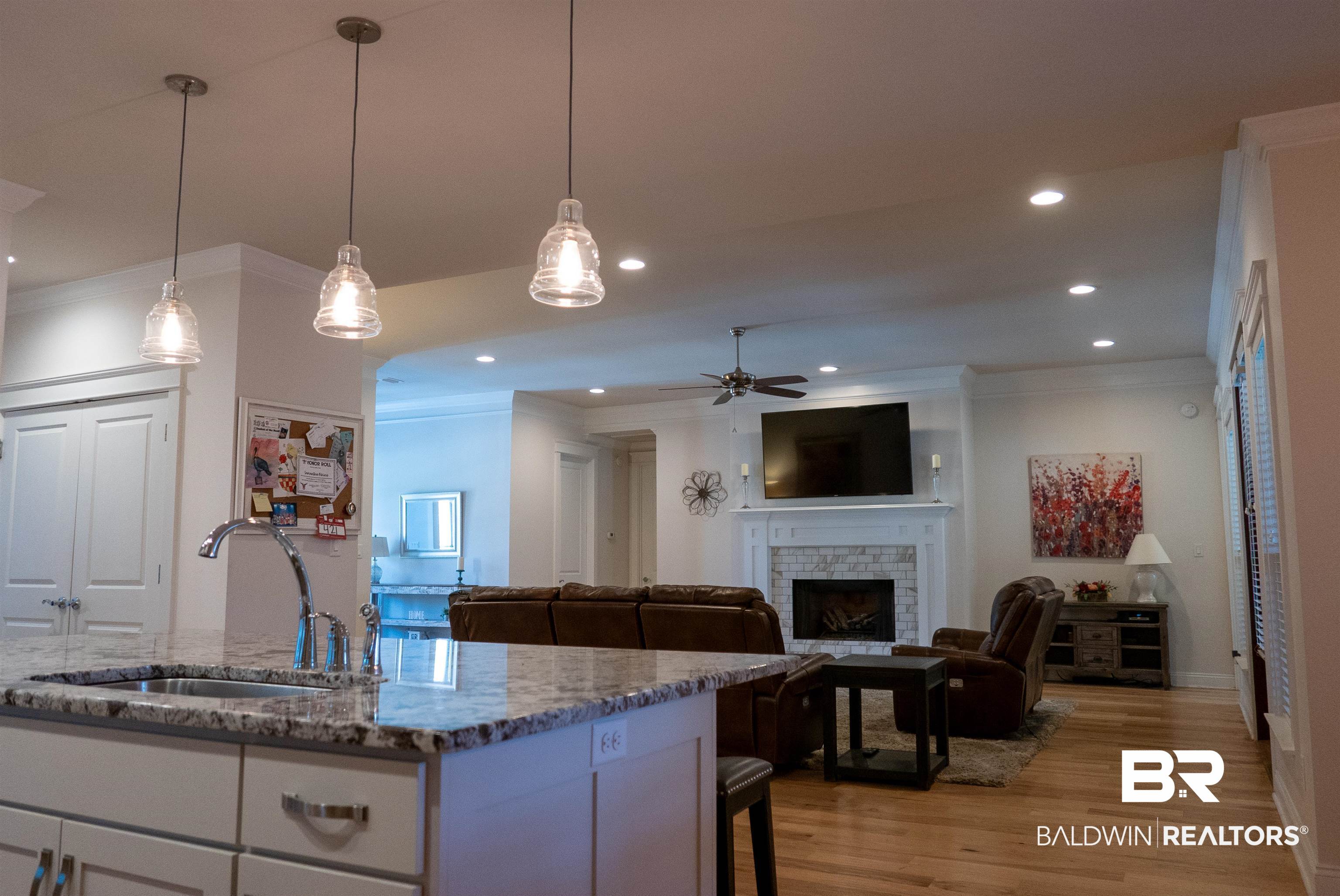 6684 Garrison Drive Daphne, AL 36527 - Photo 30 of 35 Kitchen with light hardwood / wood-style flooring, decorative light fixtures, dark stone counters, and a brick fireplace