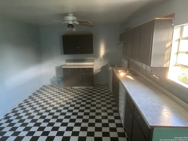 a kitchen with a sink a stove and cabinets