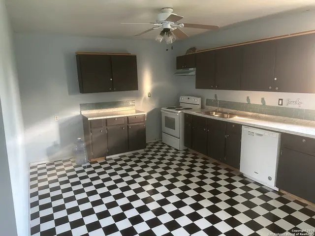 a kitchen with a sink a stove and cabinets