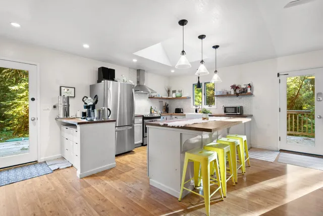 a kitchen that has a lot of white cabinets and stainless steel appliances