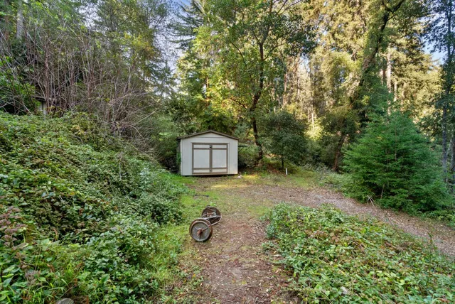 an aerial view of residential house with outdoor space and trees all around