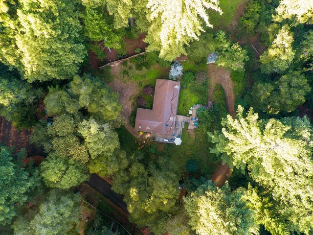 a view of a house with a wooden deck and a garden
