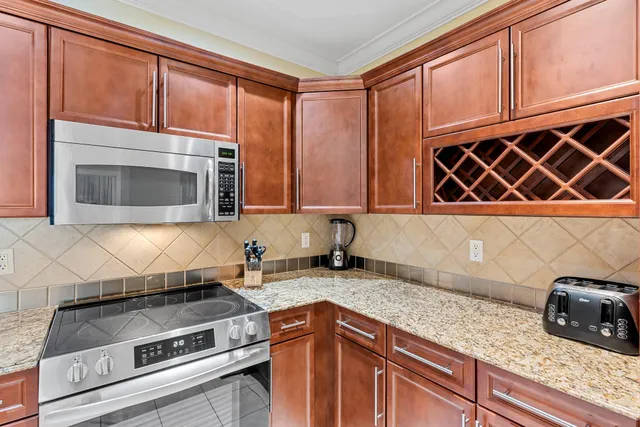 a kitchen with granite countertop cabinets and steel stainless steel appliances
