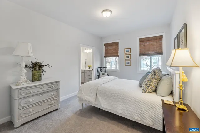 a bedroom with a bed and a lamp on dresser