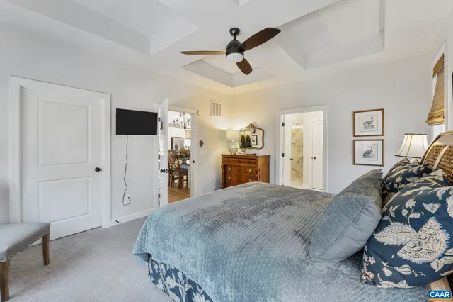 a spacious bedroom with a bed and a flat tv screen