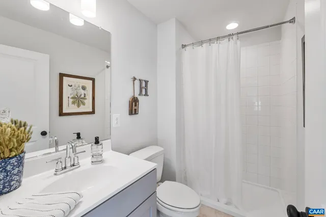 a bathroom with a sink vanity mirror and toilet
