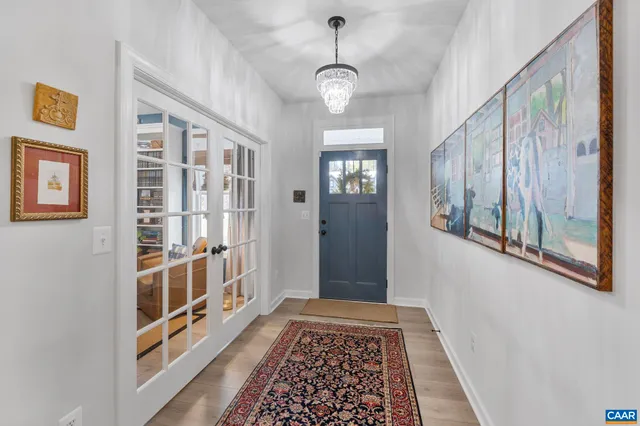 a view of a hallway with wooden floor and staircase