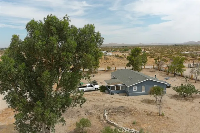 an aerial view of residential houses with outdoor space and trees