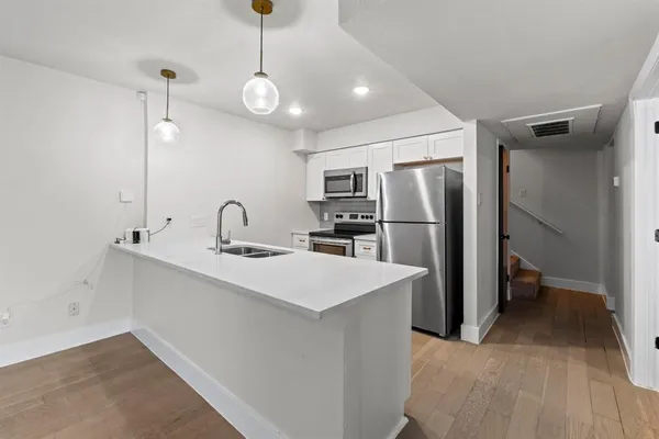 a kitchen with stainless steel appliances a sink and a refrigerator