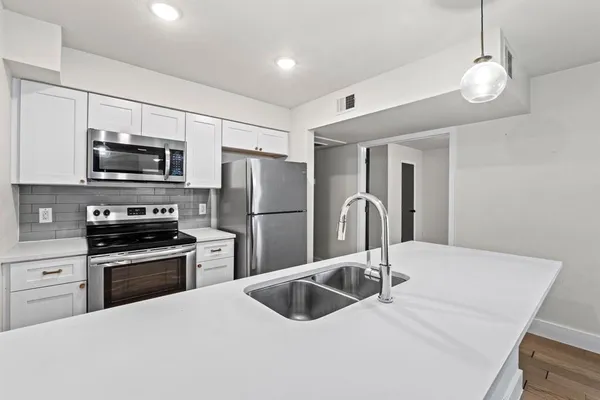 a kitchen with stainless steel appliances granite countertop a sink stove and refrigerator
