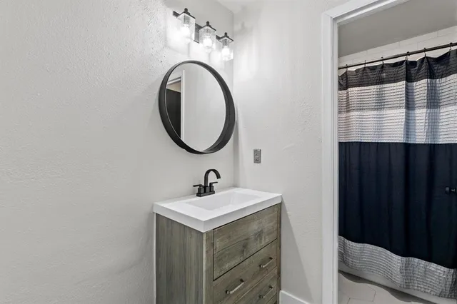 a bathroom with a sink a mirror and a shower curtain