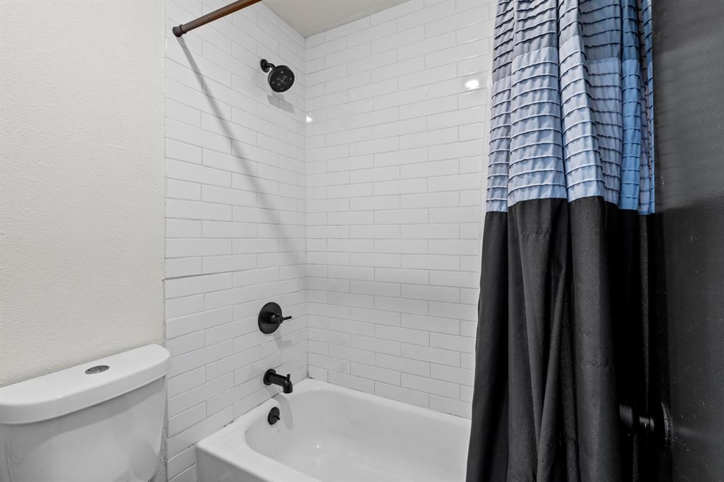 909 Reinli Street, Unit 101 Austin, TX 78751 - Photo 22 of 34 a bathroom with a shower a toilet and a tub