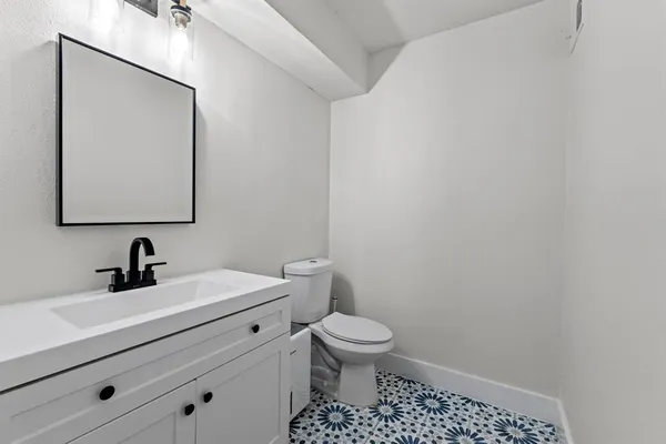 a bathroom with a toilet a sink and mirror