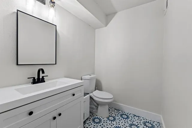 a bathroom with a toilet a sink and mirror