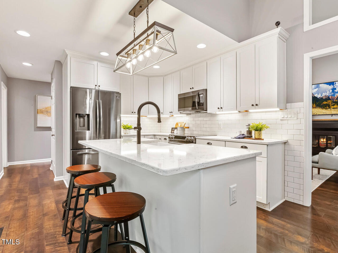 3900 Maplefield Drive Raleigh, NC 27613 - Photo 20 of 58 a kitchen with kitchen island a stove and a refrigerator with wooden floor