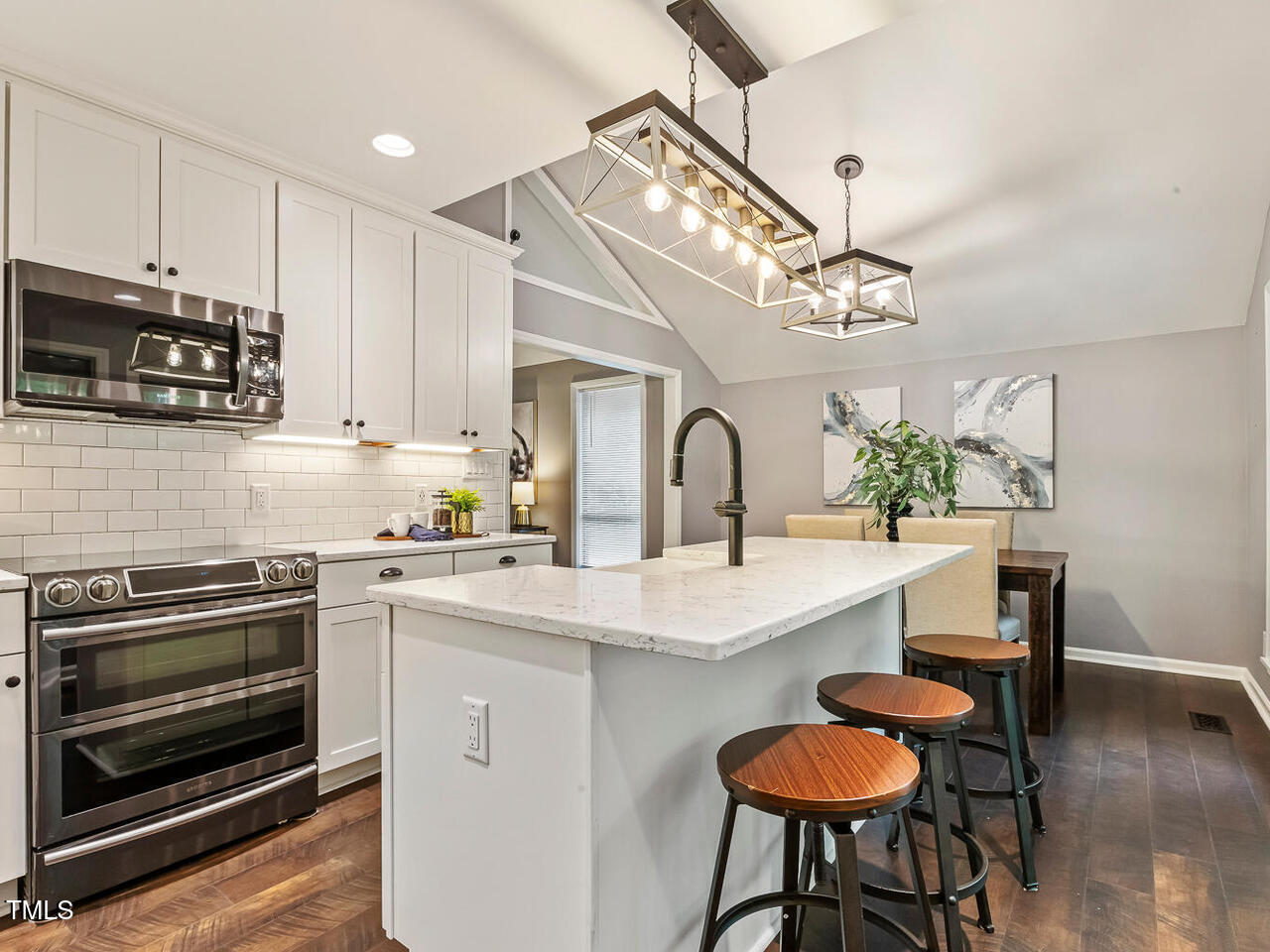 3900 Maplefield Drive Raleigh, NC 27613 - Photo 23 of 58 a kitchen with stainless steel appliances a sink a stove a table and chairs