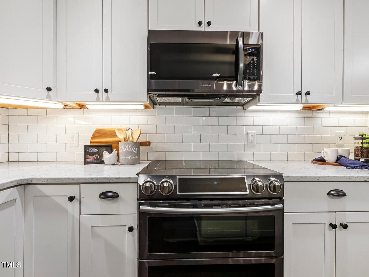 3900 Maplefield Drive Raleigh, NC 27613 - Photo 25 of 58 a kitchen with a stove and a microwave