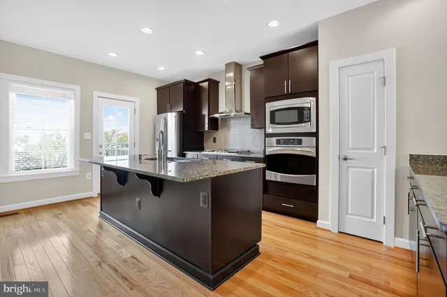 a kitchen with kitchen island granite countertop stainless steel appliances a sink and counter space